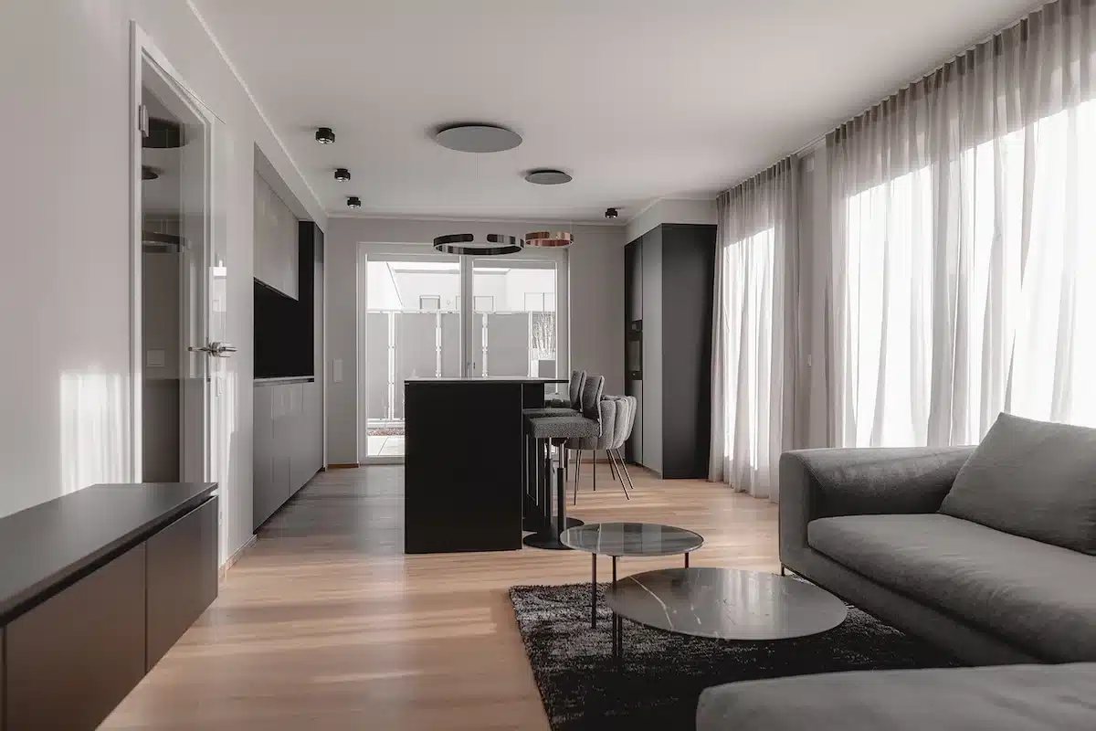 Offener Wohnbereich mit Sofa und Küche, eingerichtet von HOME