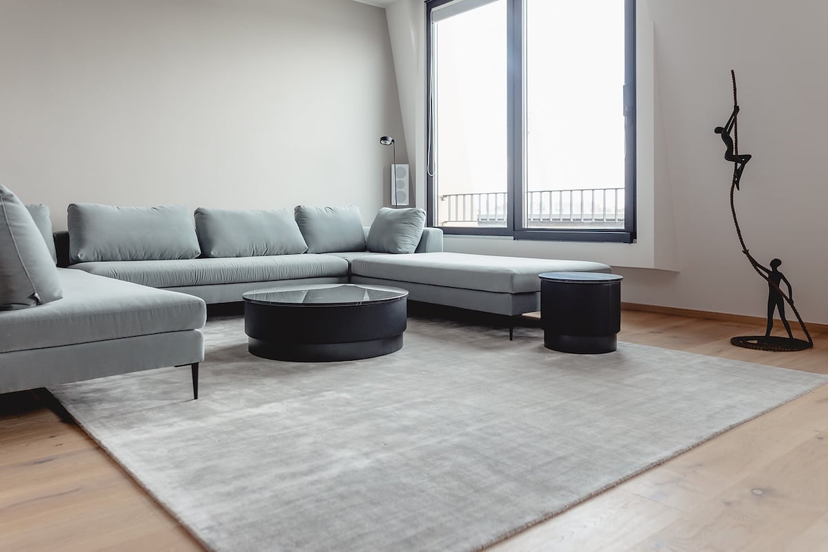 Wohnzimmer mit Ecksofa und Panoramafenster, eingerichtet von HOME in Köln