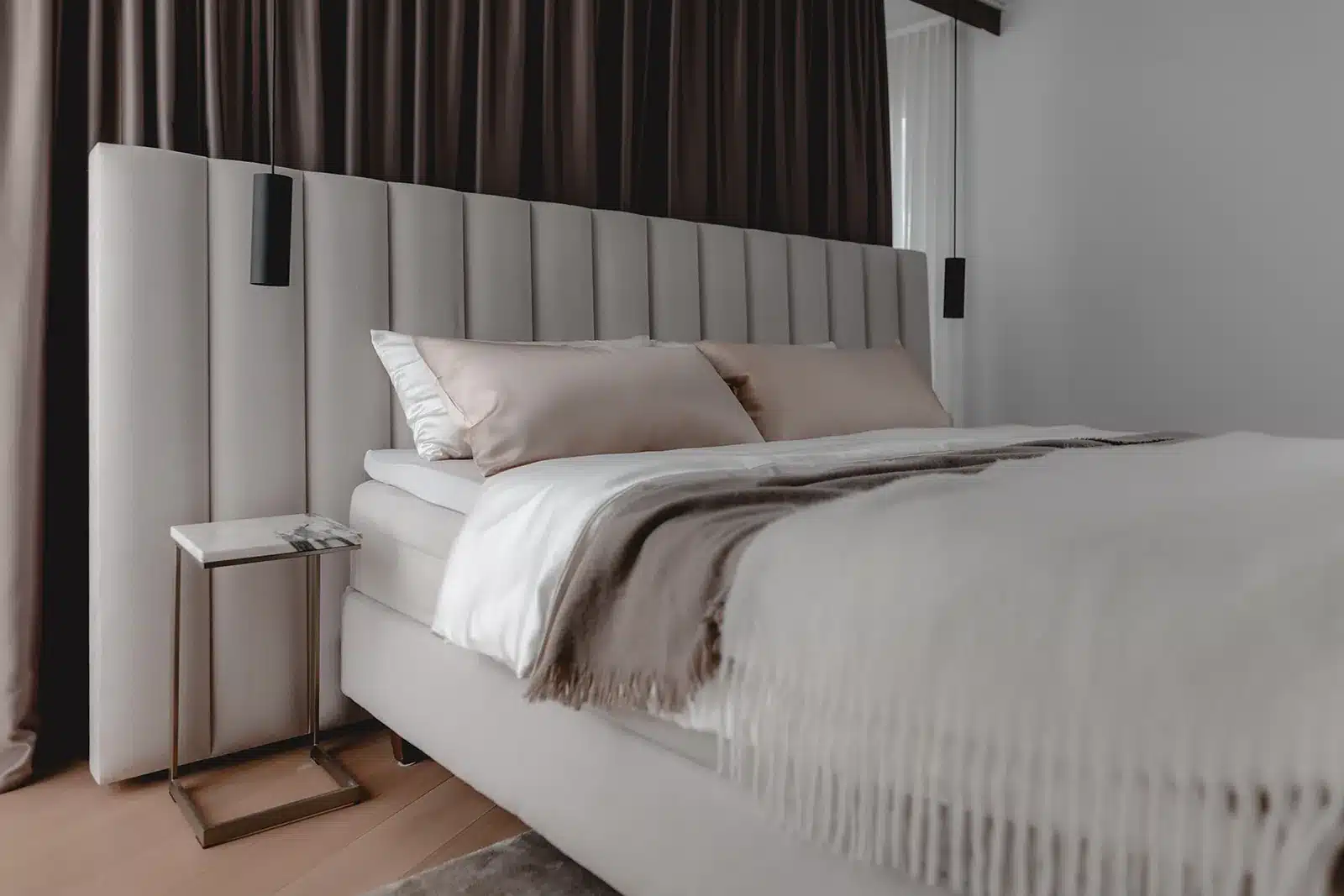 Schlafzimmer mit DUXIANA Bett und raumhohem gepolstertem Kopfteil