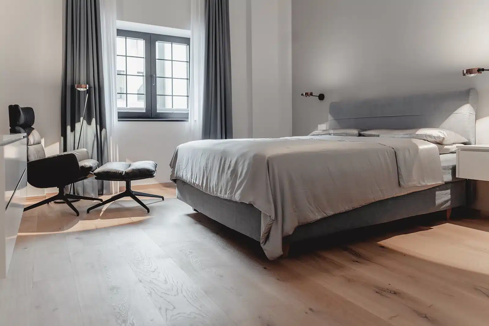 Schlafzimmer mit Boxspringbett und Leseleuchten, geplant von HOME