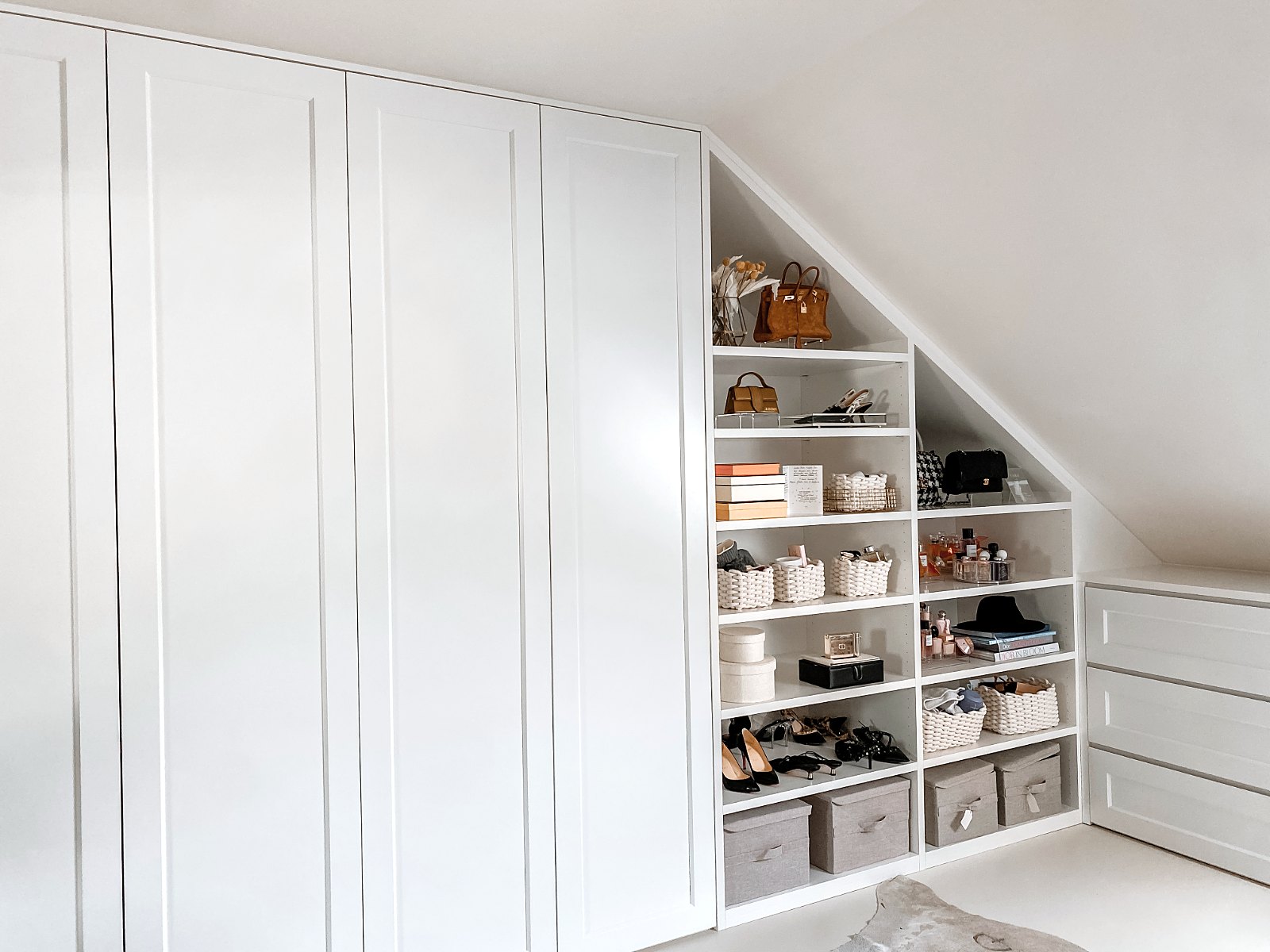 Ankleide unter der Dachschräge von Tara Tut, geplant von HOME Schlafen & Wohnen: Schrankwand mit Schuhregal