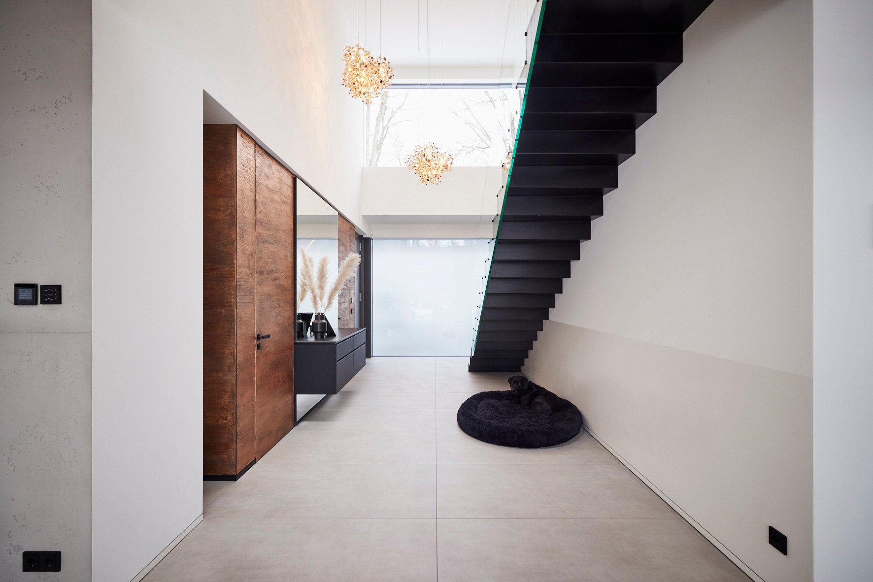 Hauseinrichtung Leipzig von HOME Schlafen & Wohnen: Treppe mit Holzwand und Designleuchte
