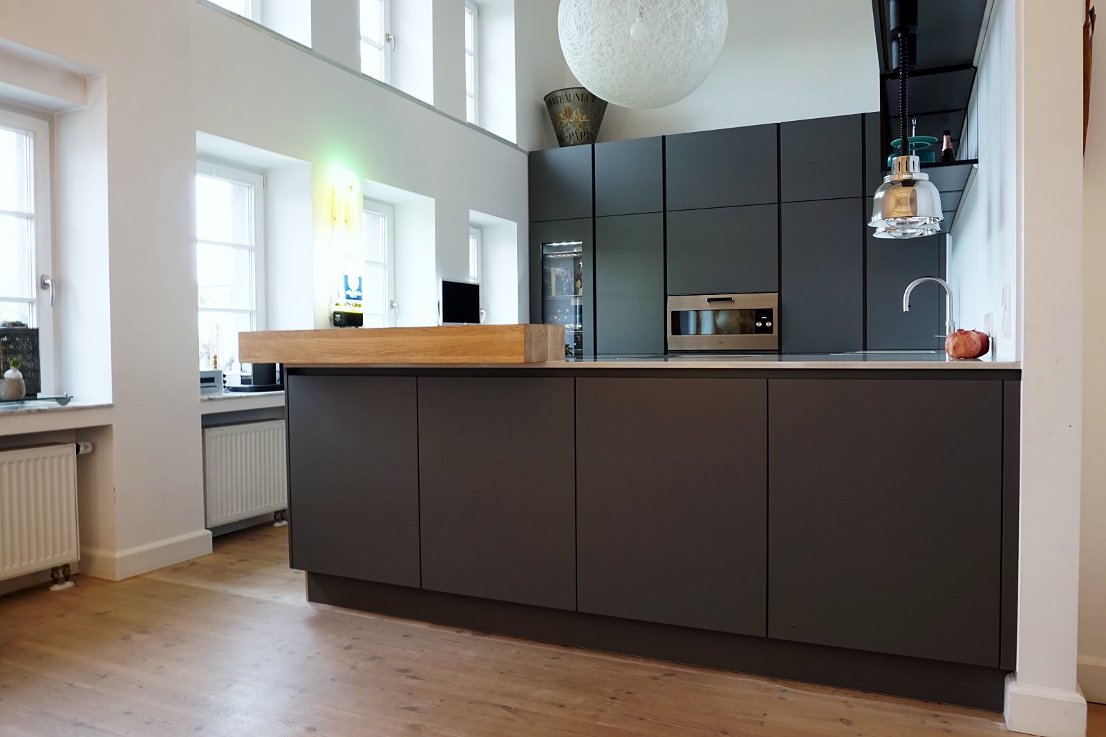 Küche in Grau mit Holz von HOME Schlafen & Wohnen: Kücheninsel mit Holzplatte
