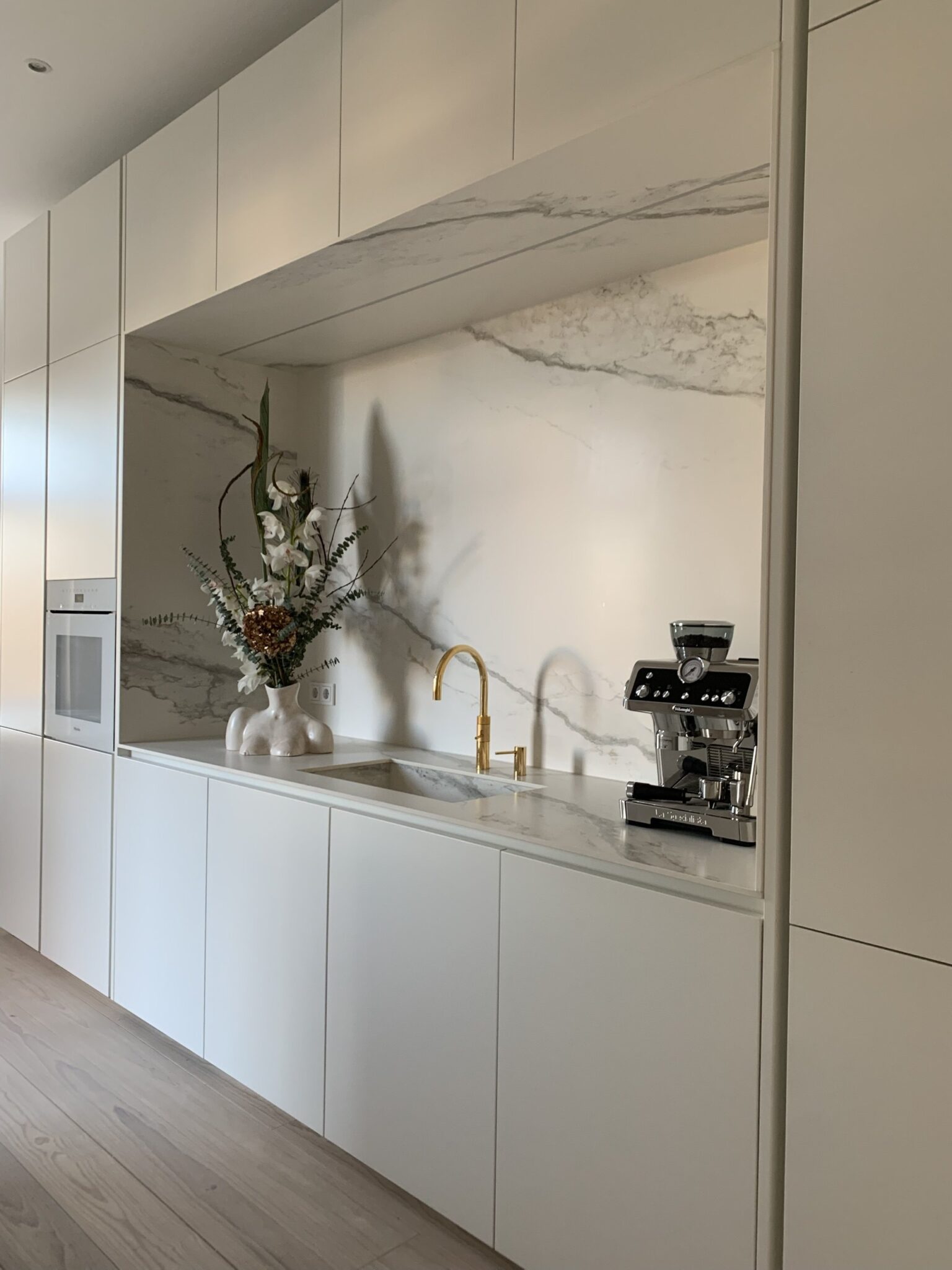 Grifflose Hochschrankwand mit Nische aus Keramik und Backofen