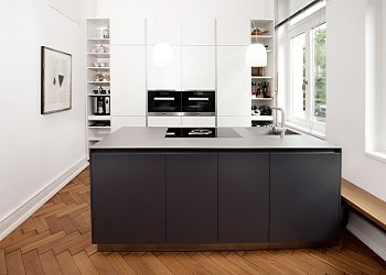 Weiße Küche mit dunkler Insel im Altbau