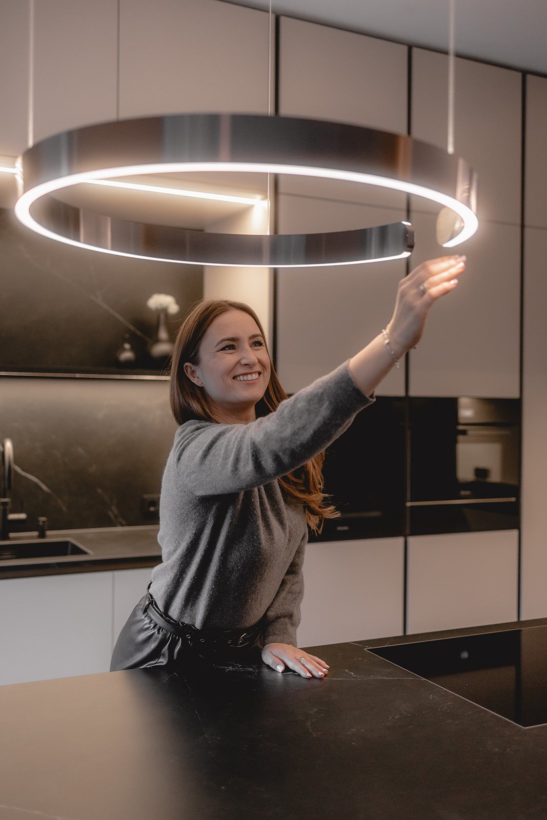 Laura Mollidor von HOME an der Ringleuchte über der Insel